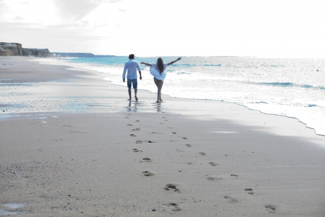 晴れの日に浜辺を歩くカップル
