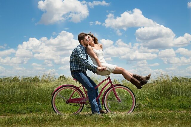 仲良く二人で自転車に乗るカップル