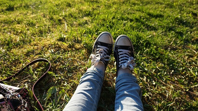 芝生で伸ばされた足