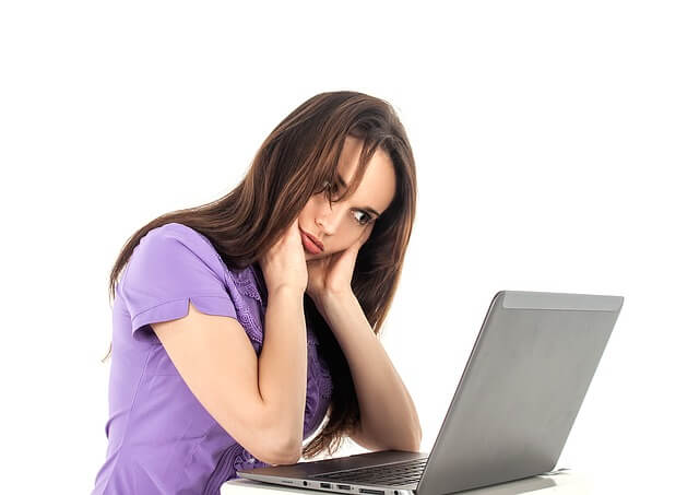 パソコンを見ながら悩む女性