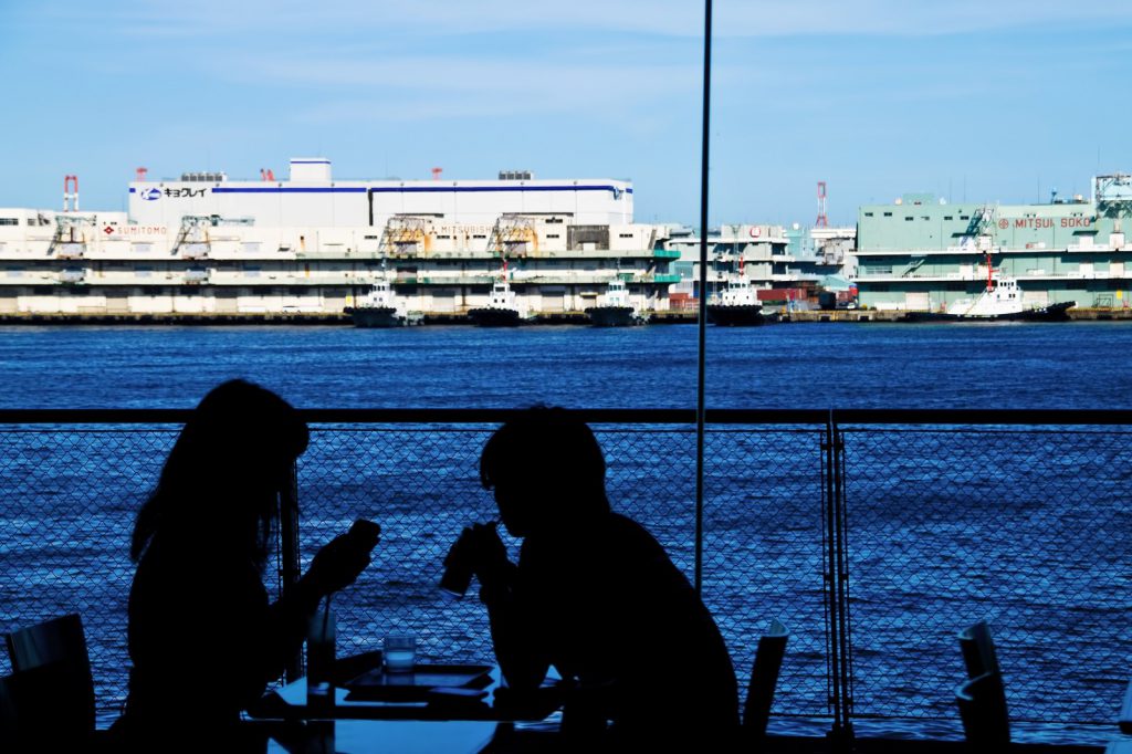 海が見えるカフェで食事を楽しむカップル
