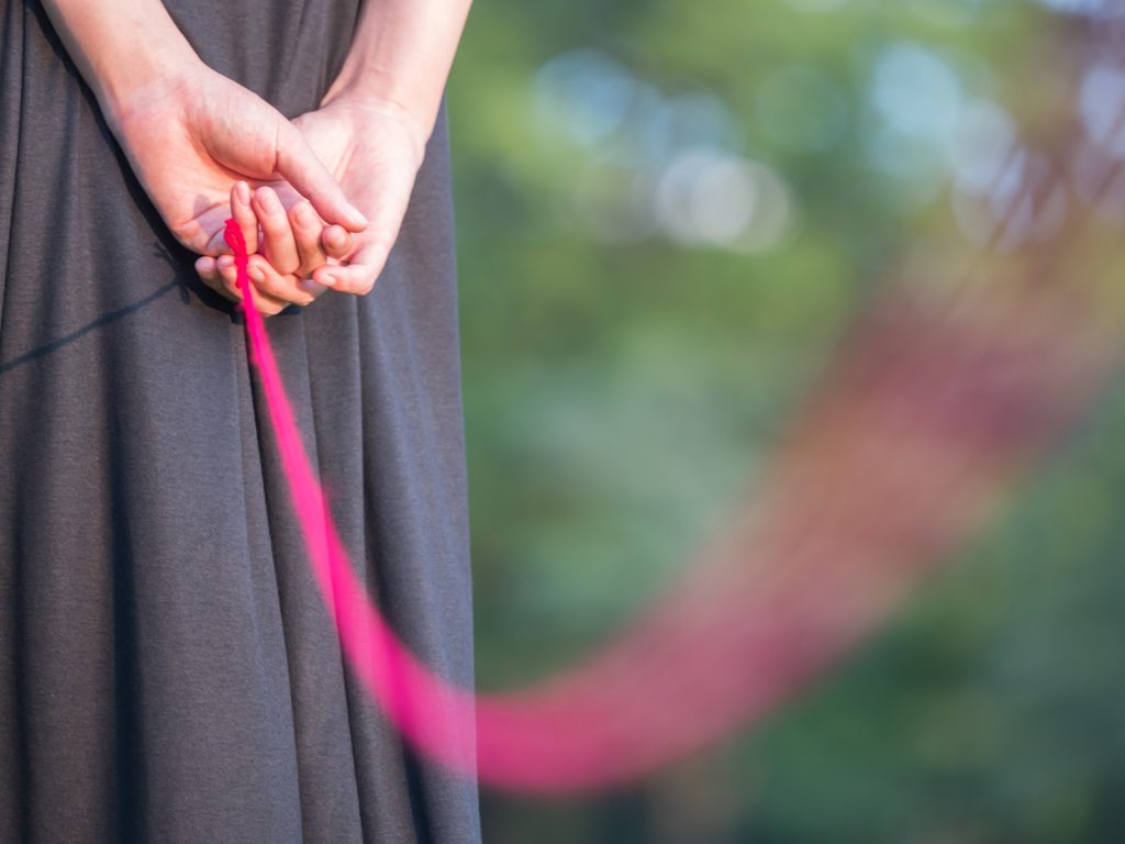 赤い糸を持つセーラー服の女性