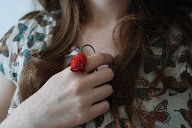 胸元にバラの花を持つ女性