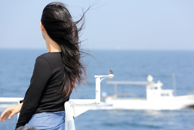 遠くの海を見つめる女性