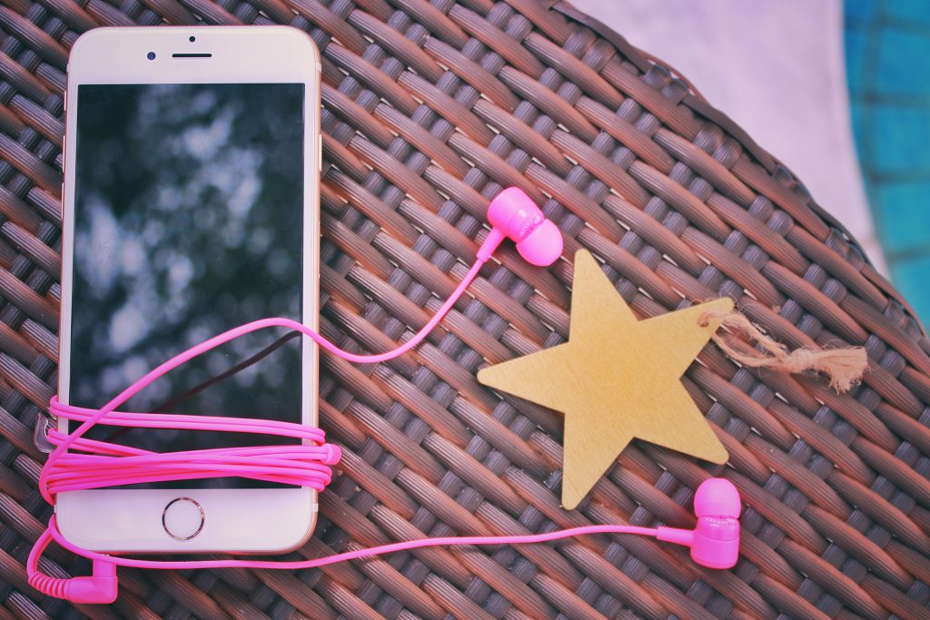 iPhoneとピンクのイヤホン