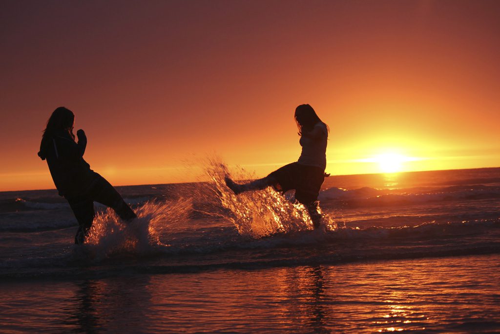 海辺で親友と遊ぶ女性